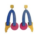 Caravanas de madera de tilo pintadas a mano en colores azul, amarillo y rosa, con baño de barniz transparente.