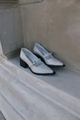 Mocasines color visón de charol con punta cuadrada y tira sobre el empeine.