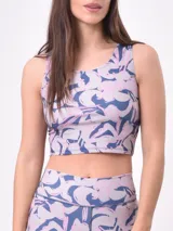 Top deportivo corto estampado con flores abstractas en tonos azul, lila y rosa. Diseño de espalda deportiva.