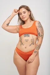 Conjunto de bikini color naranja, compuesto por un corpiño tipo top deportivo y una bombacha clásica.