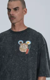 Remera negra con efecto acid wash, corte holgado y estampa frontal de Bao, personaje de Disney.