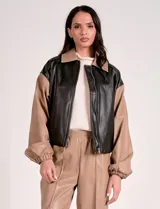 Campera bomber de cuero sintético negra con mangas color beige, cuello clásico y cierre frontal con cremallera.