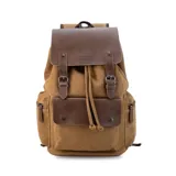 Mochila de tela canvas color marrón con detalles en símil cuero marrón. Tiene cierre superior tipo marinero, bolsillos internos y externos con cierre metálico, asas rígidas y correas ajustables.