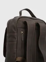 Mochila de cuero marrón con bolsillo frontal con cierre y dos bolsillos con hebilla. Tiene asa de mano y correas acolchadas ajustables.