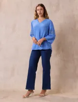 Blusa celeste de gasa bambula con cuello a la base y escote en V. Manga ¾ amplia, con aplique de crochet en los puños.