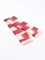 Pañuelo rectangular con estampado abstracto en tonos terracota, negro, blanco y beige.