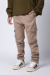 Pantalón cargo color beige con bolsillos laterales con solapa y botón. Corte ajustado.