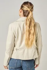 Campera estilo motociclista de cuero color marrón caramelo, con cuello solapa, cierre asimétrico plateado y detalles de broches metálicos.