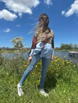 Camisa de manga larga con estampado animal print, mangas marrones y detalle celeste en la parte inferior.