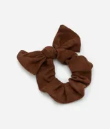 Coletero scrunchie de tela texturizada color marrón con lazo.