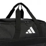 Bolso deportivo Adidas Tiro L Duffle, color negro con logo blanco, con doble asa de mano y correa ajustable para el hombro. Incluye compartimento principal con cierre, bolsillo lateral con cierre y bolsillo interior. Ideal para transportar ropa y calzado deportivo.