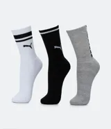 Kit de tres pares de medias deportivas Puma de caña larga. Un par color beige con dos rayas marrones horizontales en la parte superior y logo marrón en el tobillo. Un par color crema liso con logo blanco en el tobillo. Un par color marrón con una raya blanca horizontal en la parte superior y logo blanco en el tobillo.