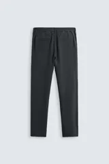 Pantalón negro de corte recto, confeccionado en tejido de mezcla de algodón y lino. Presenta cintura elástica, bolsillos laterales y traseros.