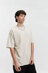 Remera de manga corta color marrón claro, de corte amplio y cuello redondo.