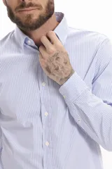 Camisa celeste a rayas verticales, de corte clásico, con cuello abotonado y mangas largas.