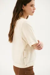 Blusa color crudo de lino con cuello redondo y mangas cortas.