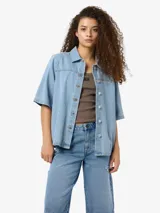 Camisa de denim celeste con cuello clásico, mangas cortas y cierre con botones.