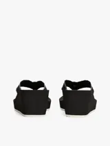 Ojotas negras con plataforma de cuña, tiras de tejido con ribete blanco y logo TH dorado en la tira del dedo.