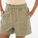 Short color verde militar, de tiro alto con cintura elastizada y lazo ajustable. Tiene bolsillos laterales y dos bolsillos grandes de parche en el frente.