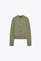 Chaqueta de punto color rosa pálido, con cuello redondo y cierre frontal de botones oscuros. Presenta mangas largas y un corte a la cintura.