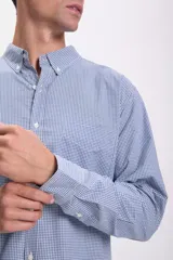 Camisa celeste con estampado de cuadros pequeños en blanco, de corte clásico, manga larga y cuello abotonado.