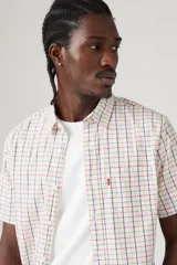 Camisa de manga corta a cuadros color blanco, naranja y azul. Tiene un bolsillo en el pecho con el logo de la marca.