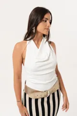 Top blanco de cuello volcado, confeccionado en tejido de punto suave y adaptable.