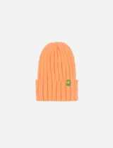 Gorro tejido color salmón con textura acanalada, ideal para complementar looks de invierno.