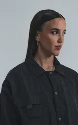 Campera negra oversize con broches en el delantero, forrada con red, múltiples bolsillos con detalles réflex y puños elásticos.