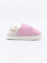 Pantuflas rosadas con interior de piel sintética color crema y suela blanca.