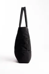Bolso grande color negro, impermeable, con cierre superior y compartimentos para laptop y botella.