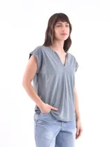 Blusa blanca de corte holgado, con cuello en V y mangas cortas.