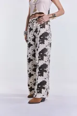 Pantalón de denim de corte wide leg con estampado de manchas de vaca.