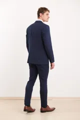 Traje de vestir azul marino, compuesto por saco de dos botones y pantalón de corte slim. Incluye camisa blanca de vestir y zapatos marrones acordonados.