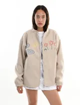 Chaqueta beige de simil paño con cierre frontal y bordado manual de flores, sol y nubes.