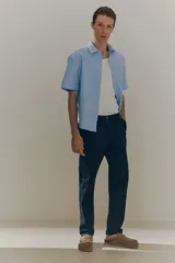 Pantalón de vestir negro de corte slim fit, con bolsillos laterales y traseros.