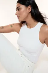 Body blanco colaless de punto elástico suave con escote redondo, sin mangas y botones a presión ocultos en la entrepierna.