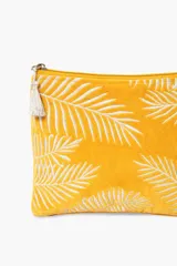 Sobre de terciopelo color amarillo con bordado de hojas de palmera en blanco y borla de hilo de lurex.