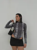 Body de diseño ajustado con estampado de serpiente y cuello alto, de manga larga.
