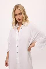 Vestido camisero a rayas verticales de colores pastel, con cuello camisero, cierre frontal con botones y mangas largas.