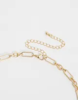 Collar corto dorado con cadena de eslabones pequeños y dijes colgantes: dado, corazón y naipe con strass.