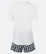 Conjunto de pijama de dos piezas compuesto por una remera de manga corta color blanco tiza con estampa de frutas en negro y un short estampado a cuadros en tonos azules y blancos.