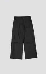 Pantalón negro con corte ancho, bolsillos laterales con solapa y detalle de cierre a la altura de la rodilla para convertirlo en short.