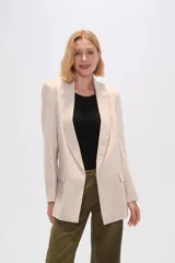 Blazer color beige de lino, con cuello solapa, corte holgado y bolsillos laterales.