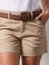 Short de jean azul oscuro, con pretina con pasadores, botón y cierre. Delantera con bolsillos. Botón en bolsillos traseros. Incluye cinturón trenzado marrón con hebilla redonda dorada.