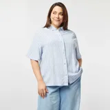 Camisa celeste y blanca a rayas verticales, de corte holgado y mangas cortas con dobladillo.