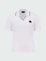 Remera polo blanca de algodón con cuello en V y ribete negro. Logo de la marca en el pecho.