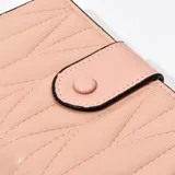 Billetera rosa con diseño acolchado y cierre de botón.
