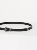 Cinturón negro de cuero vacuno con hebilla metálica plateada estilo western y puntera metálica.