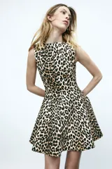 Vestido corto sin mangas con estampado de leopardo. Modelo con escote bote, cierre oculto en un lateral y pollera con vuelo.